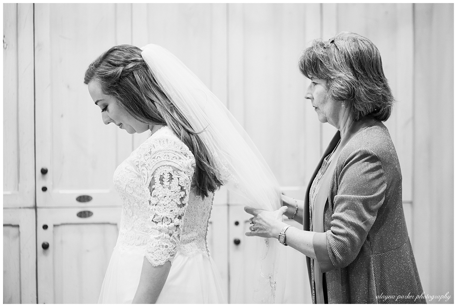 black and white image of mother fixing daughter's veil