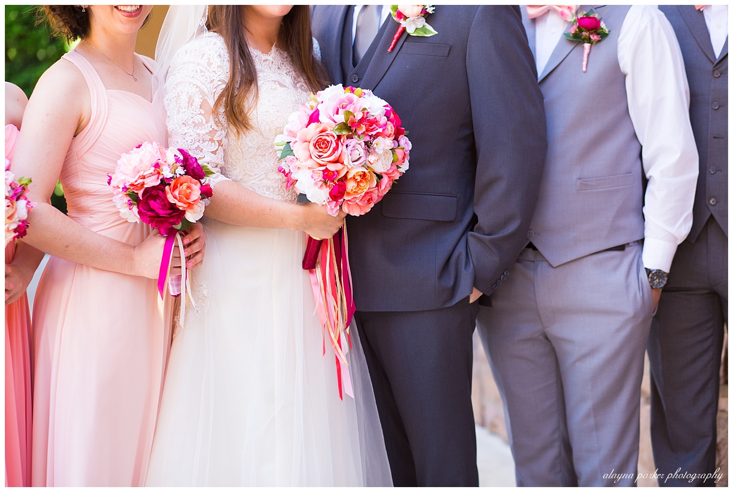 groomsmen in gray suits and bridesmaids in pink dresses
