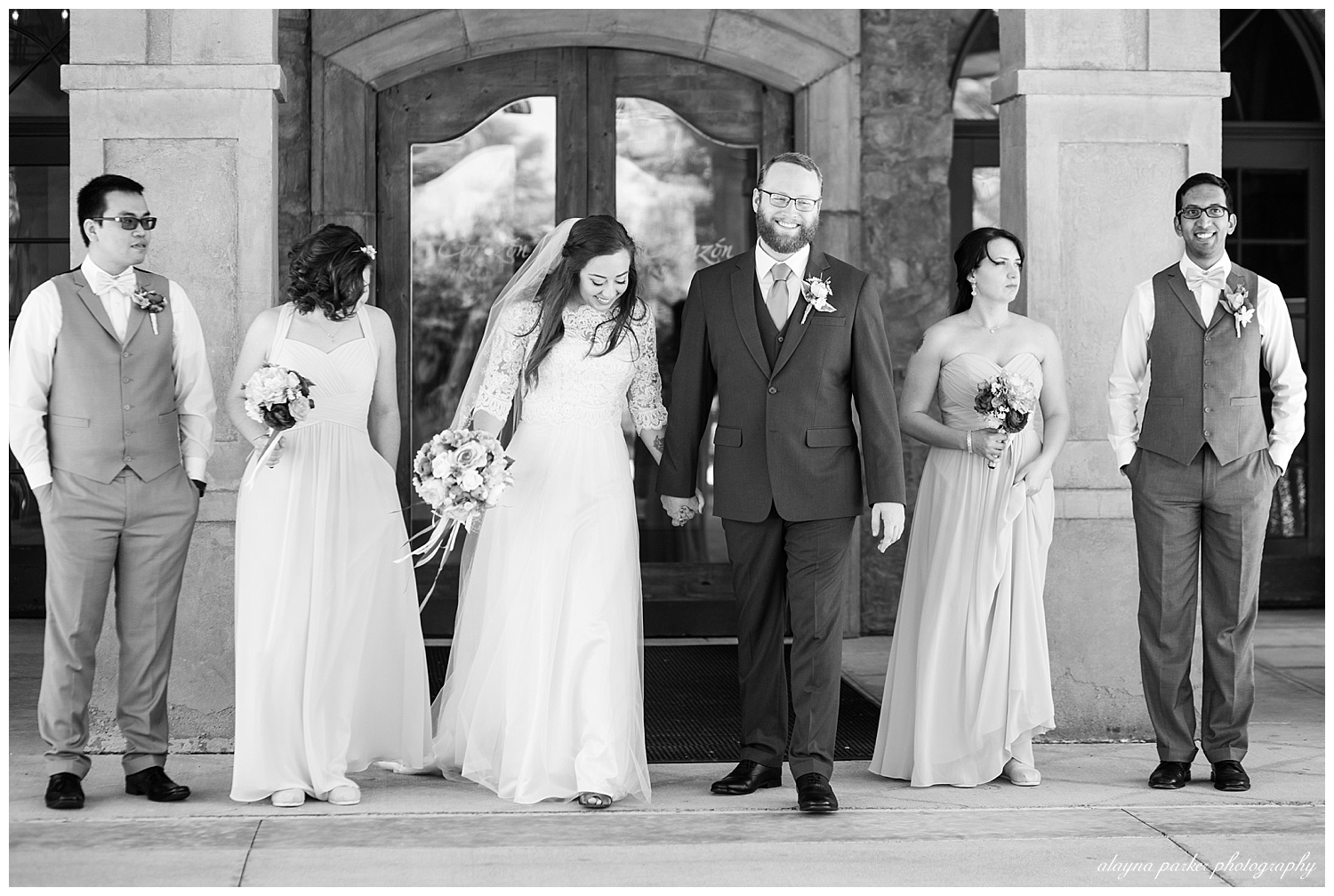 black and white image of bridal party walking at entrance to club at corazon