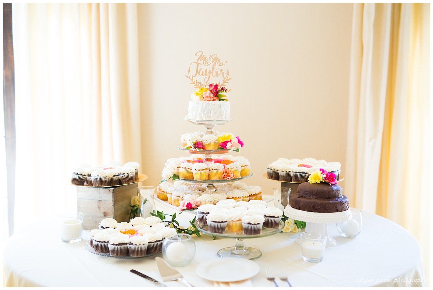 dessert table with cupcakes, white cake, and chocolate cake