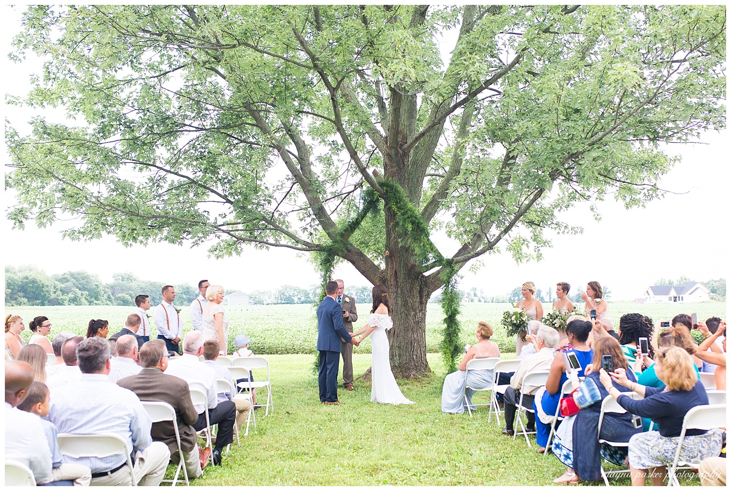 wedding ceremony in front of large tree