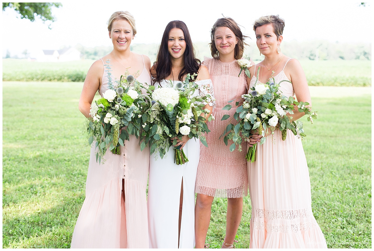 bride and bridesmaids smiling at camera
