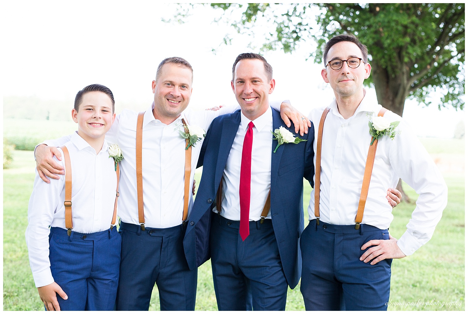 groom and groomsmen smiling at camera
