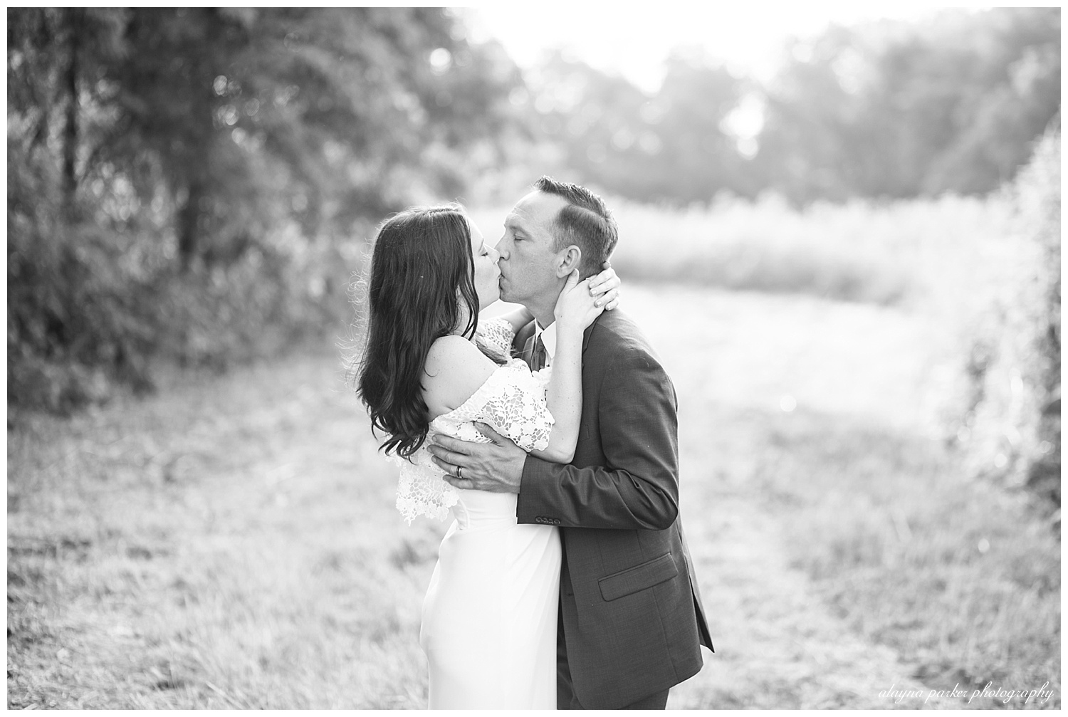 black and white image of bride and groom kissing