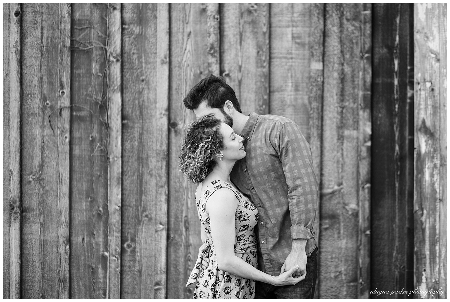 black and white image of man kissing woman on the cheek