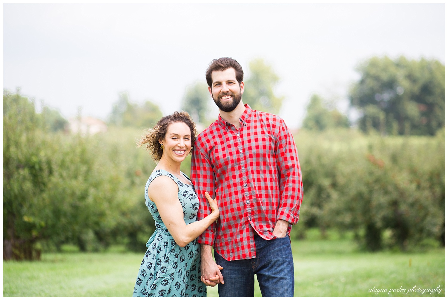 man and woman looking at camera at apple orchard