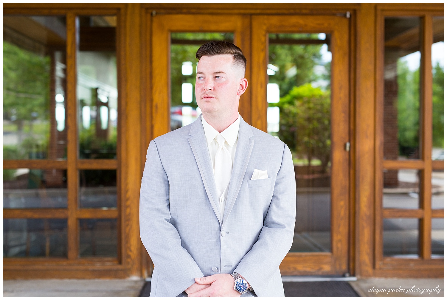 groom looking to the side in front of south pointe golf club