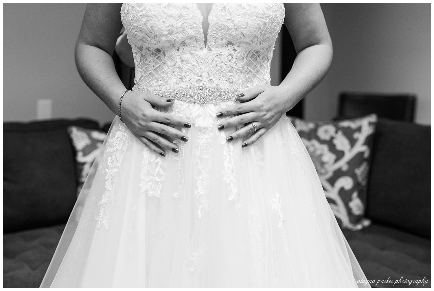 close up of brides hands while she puts dress on