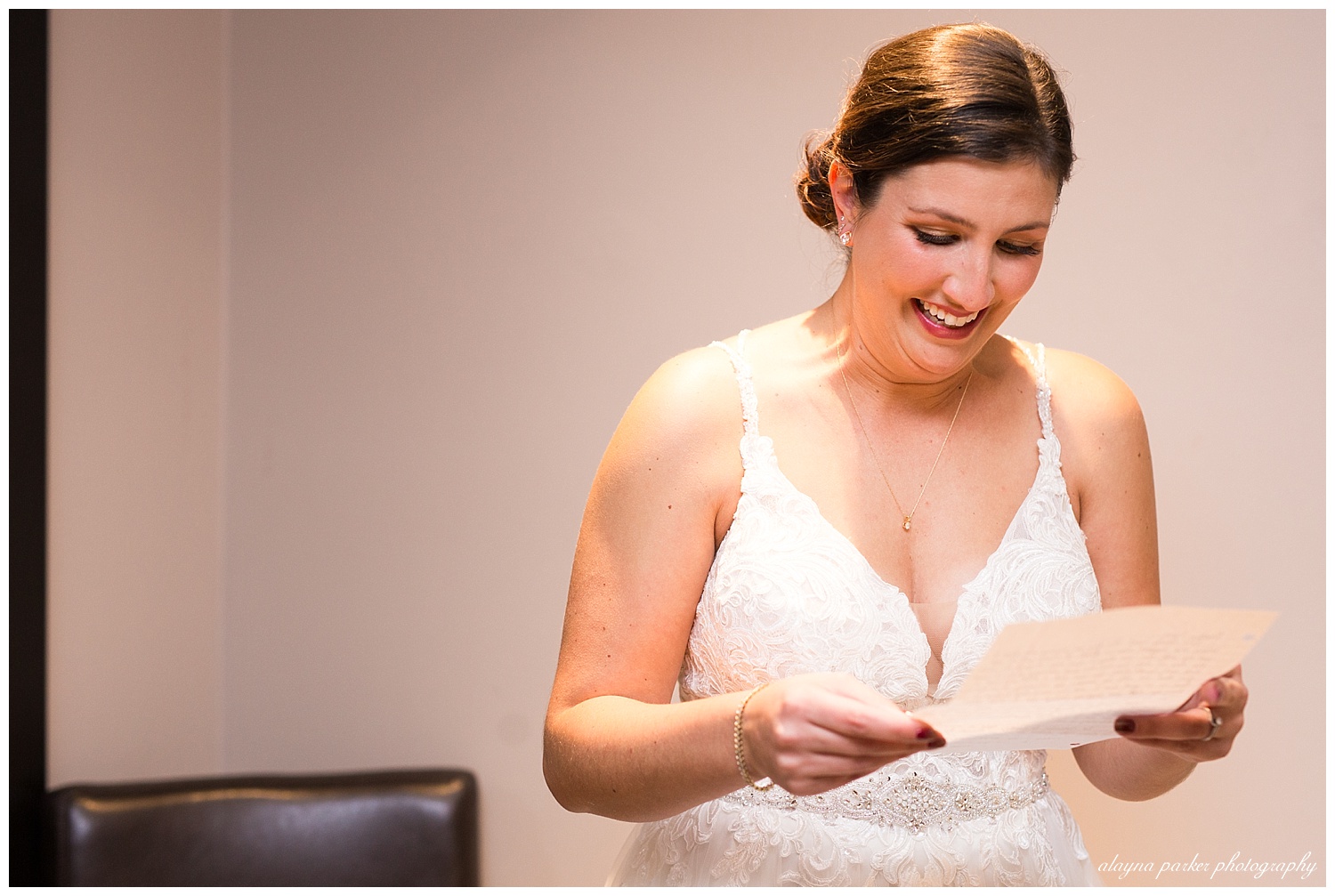bride laughing as she reads letter from groom