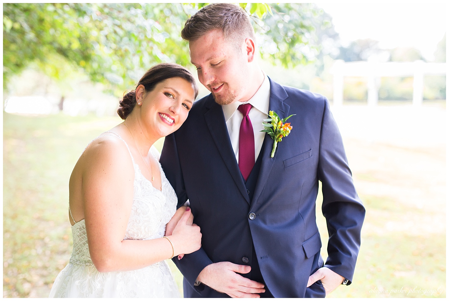 bride leaning on groom's shoulder outside water's edge