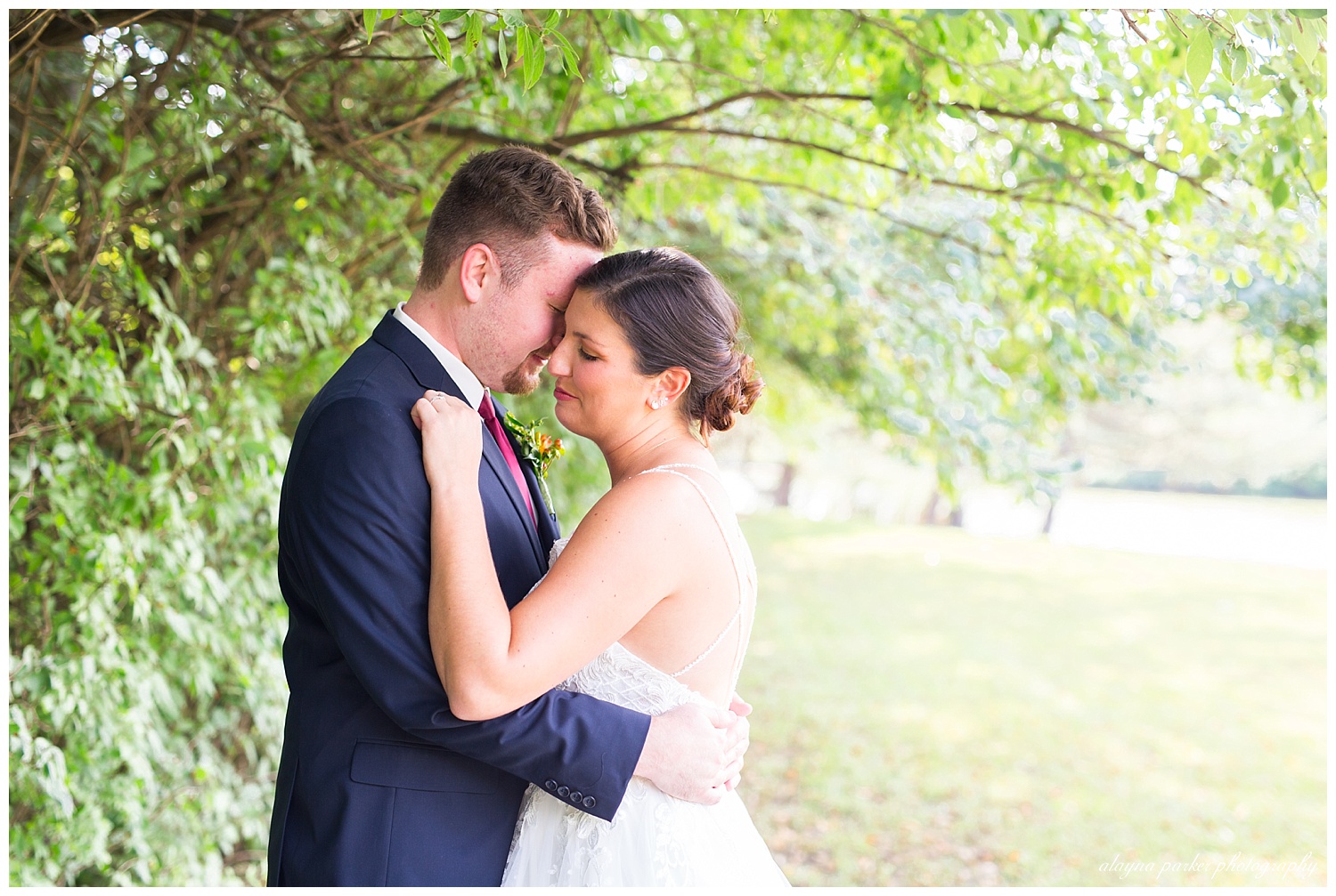 bride and groom having an intimate moment outside at water's edge