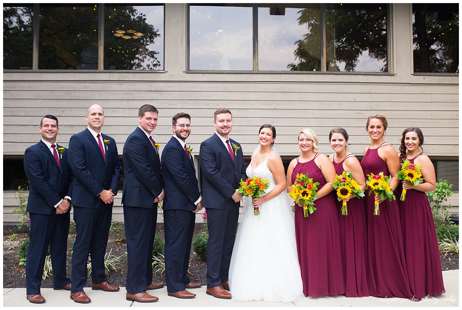 groomsmen wearing navy suits and bridesmaids wearing burgundy dresses