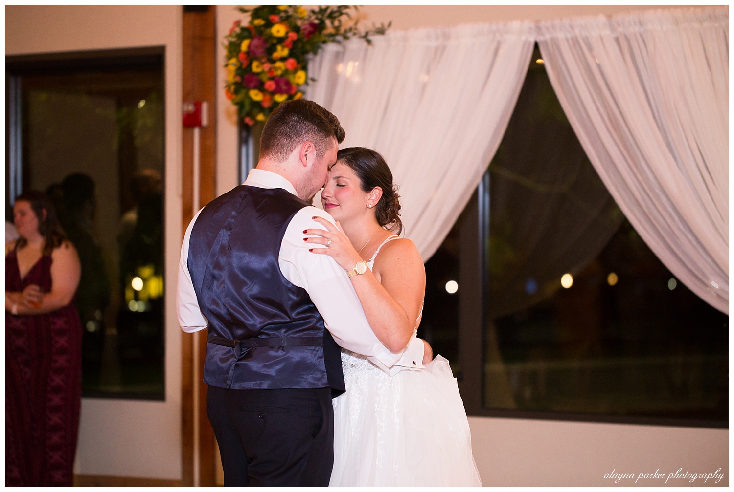 bride and groom sharing first dance at water's edge