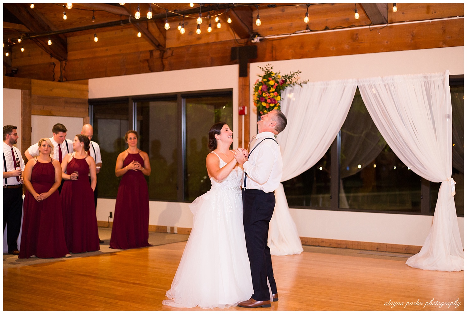 bride and father laughing during dance at water's edge