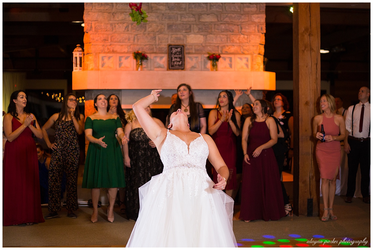 bride throwing bouquet at water's edge