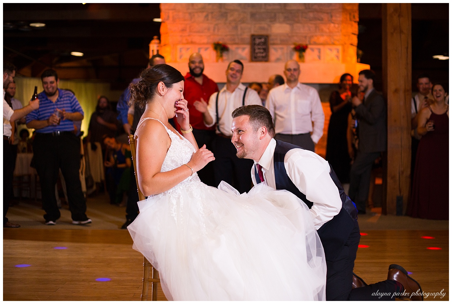 groom getting garter at water's edge