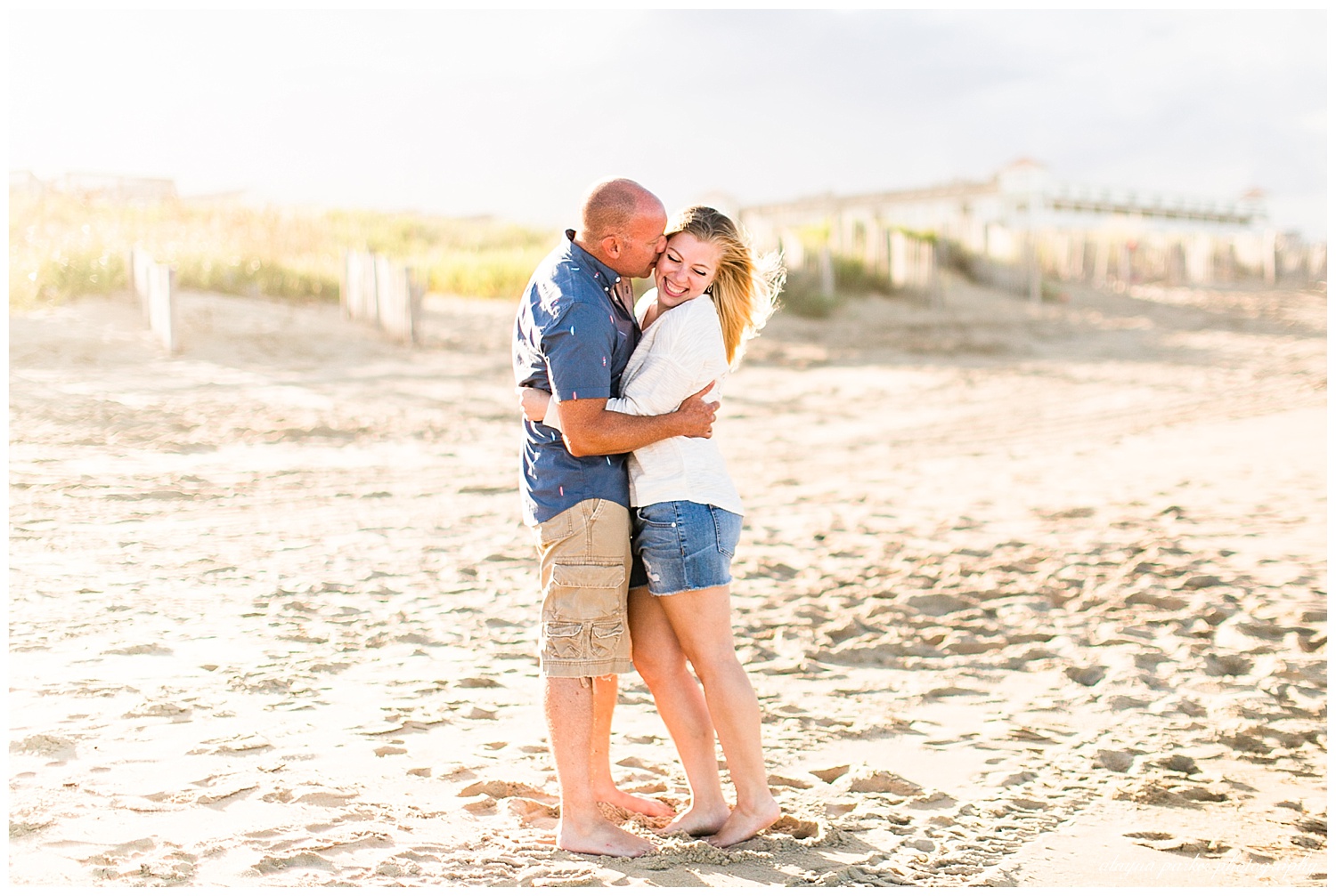 man kissing woman on cheek on beach in outer banks