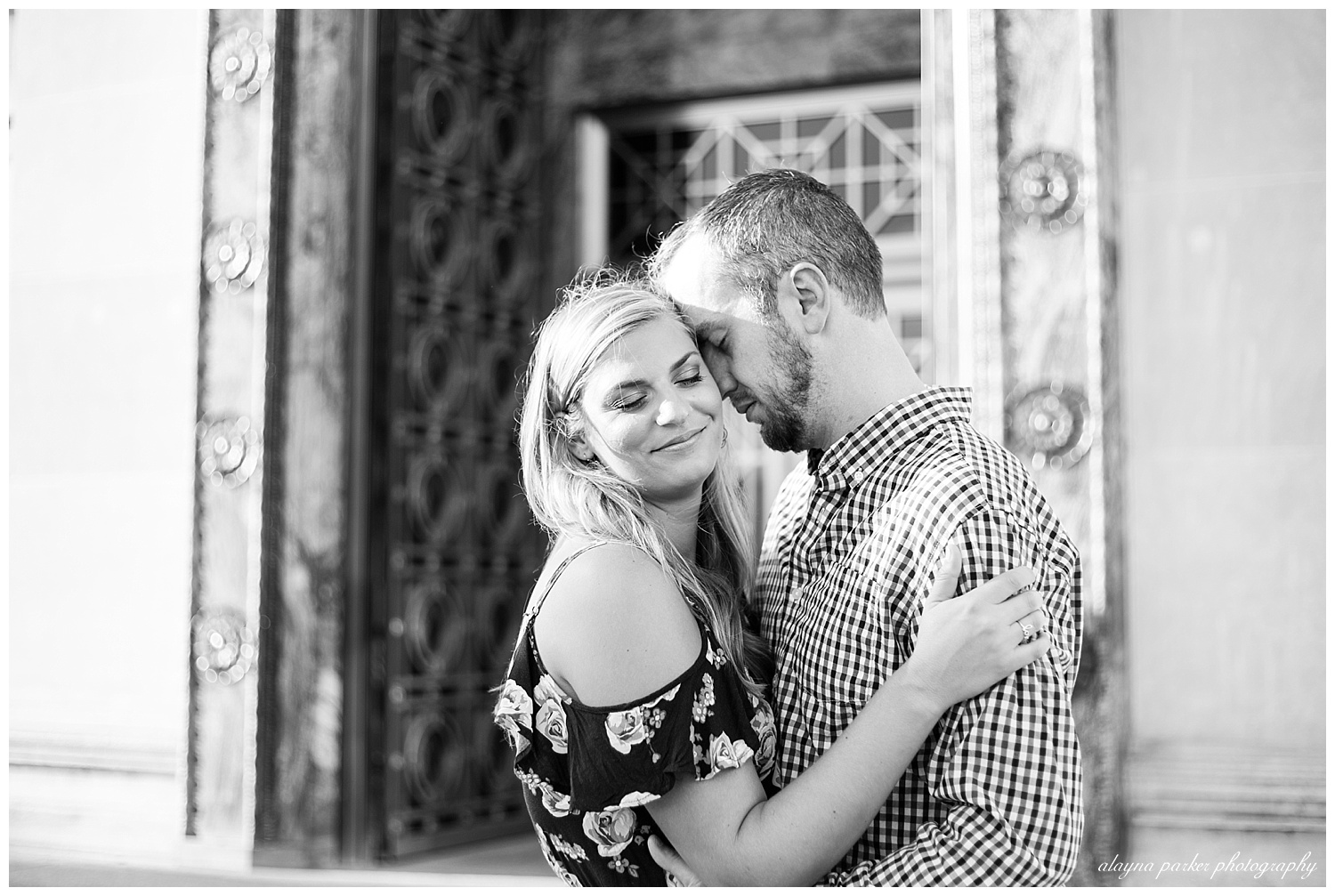 black and white image of man leaning on woman and woman closing her eyes and smiling at scioto mile