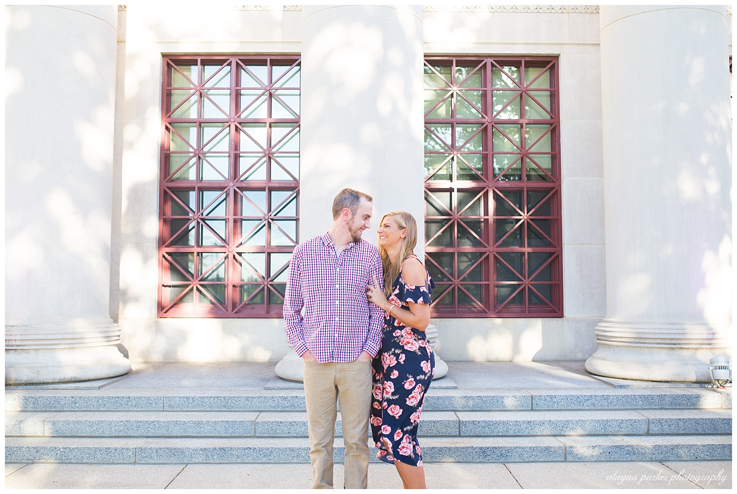 man and woman laughing at each other in front of white building at scioto mile