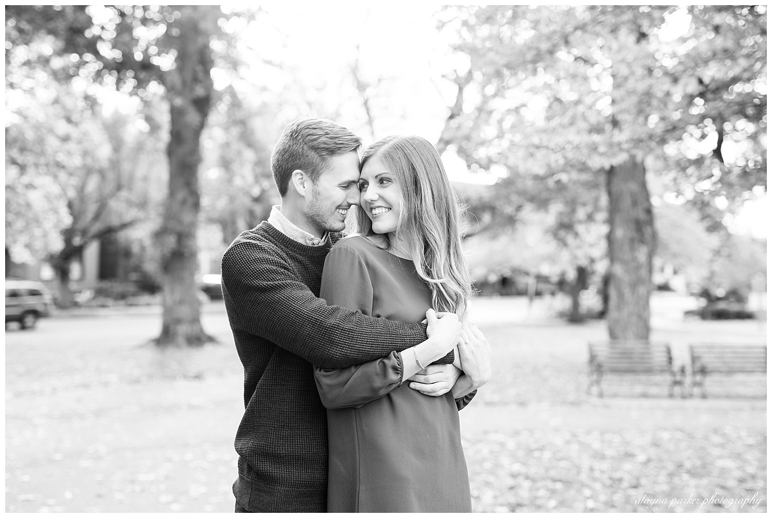 black and white image of man hugging woman from behind her at schiller park in german village