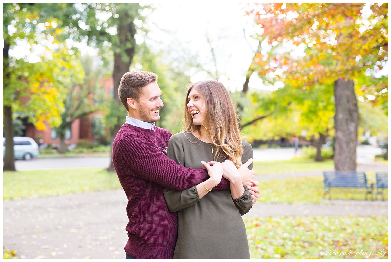 engaged couple laughing at each other at schiller park in german village