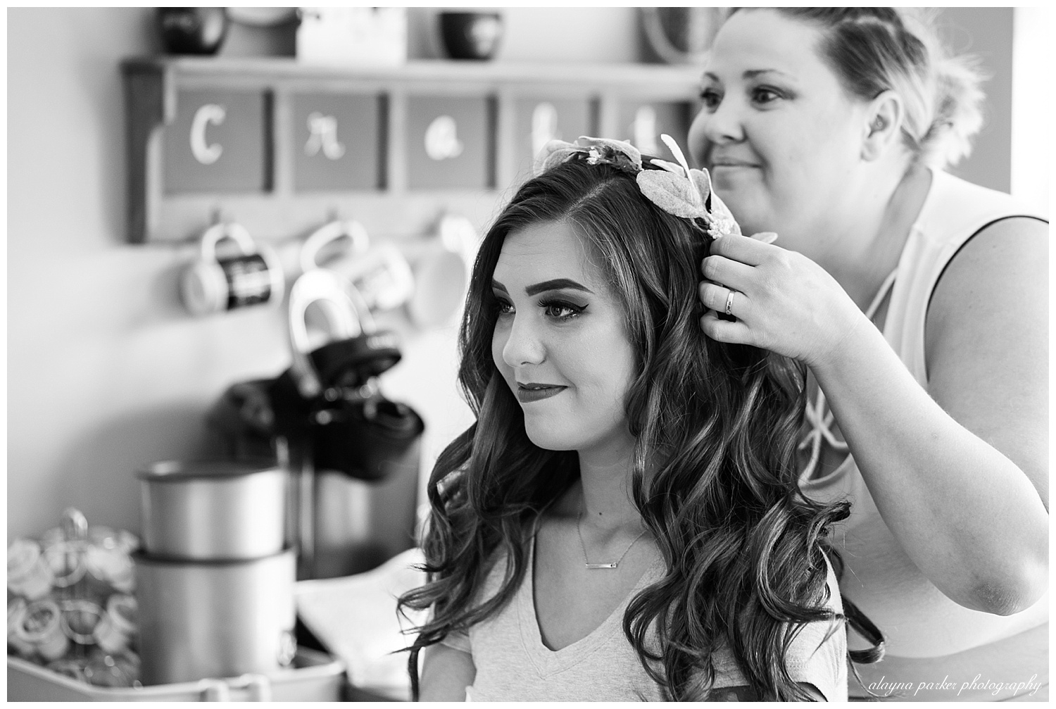 black and white image of bride getting flower crown placed on head