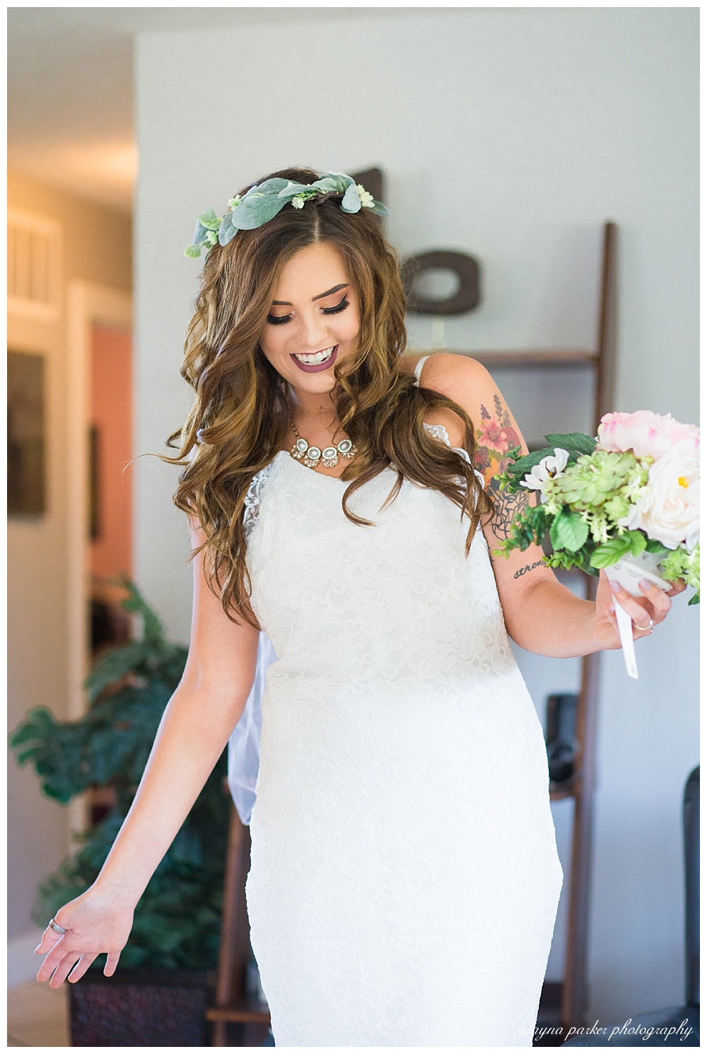 bride smiling and looking down after getting dressed in wedding gown