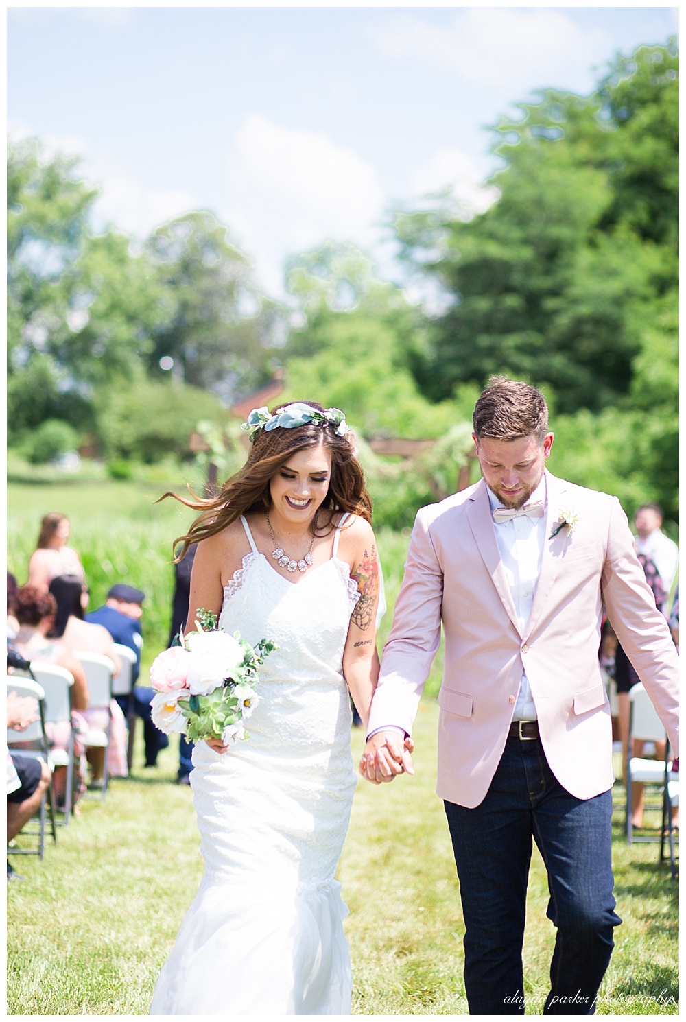 bride and groom smiling as they walk back up aisle