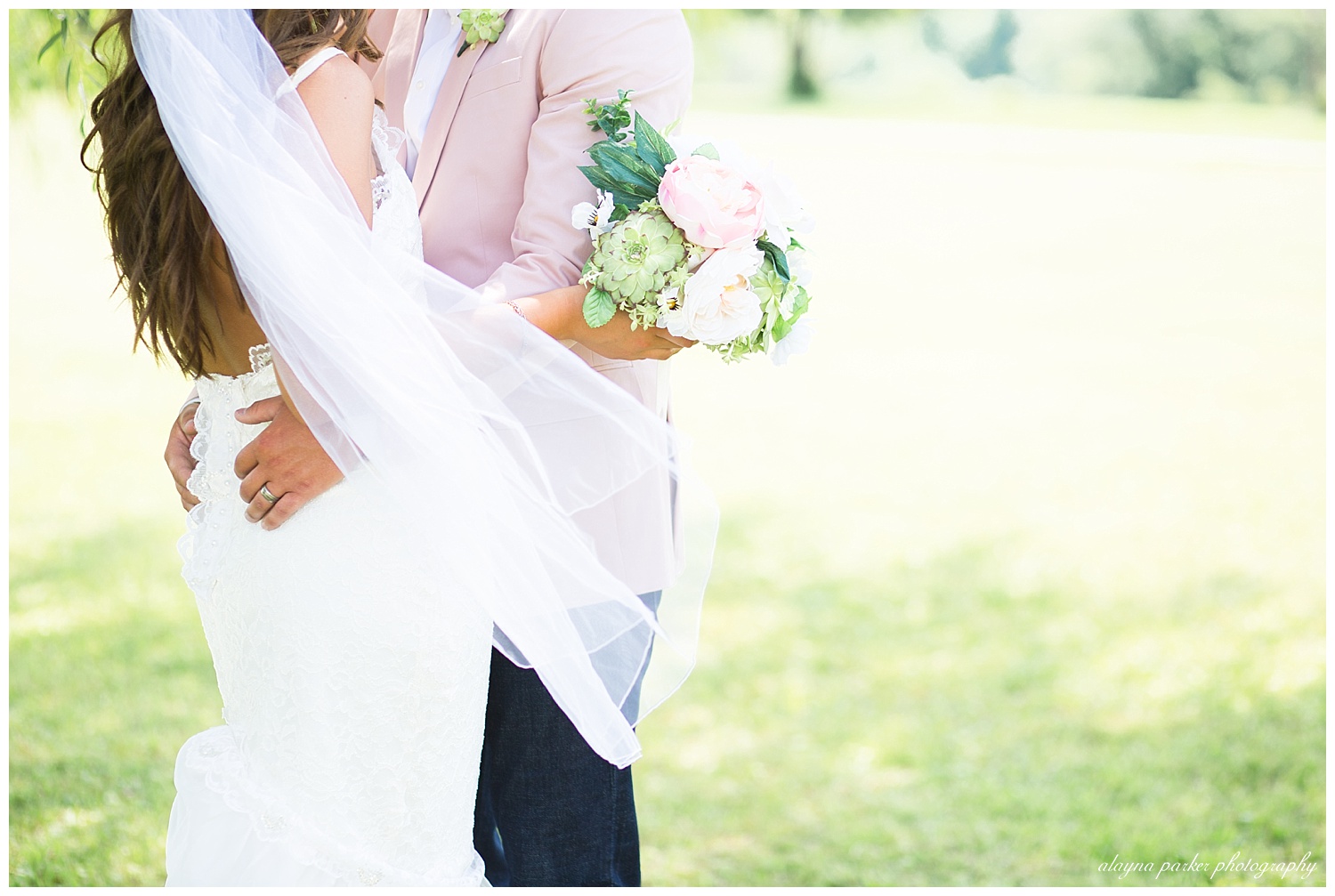 close up of groom holding onto bride and bride holding bouquet
