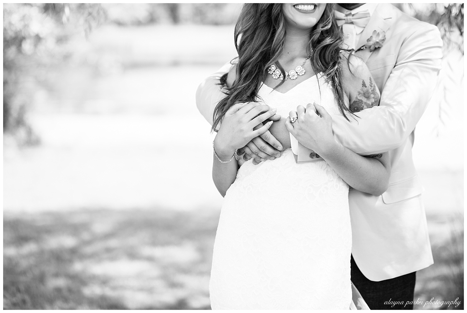 black and white image of close up of groom with arms wrapped around bride