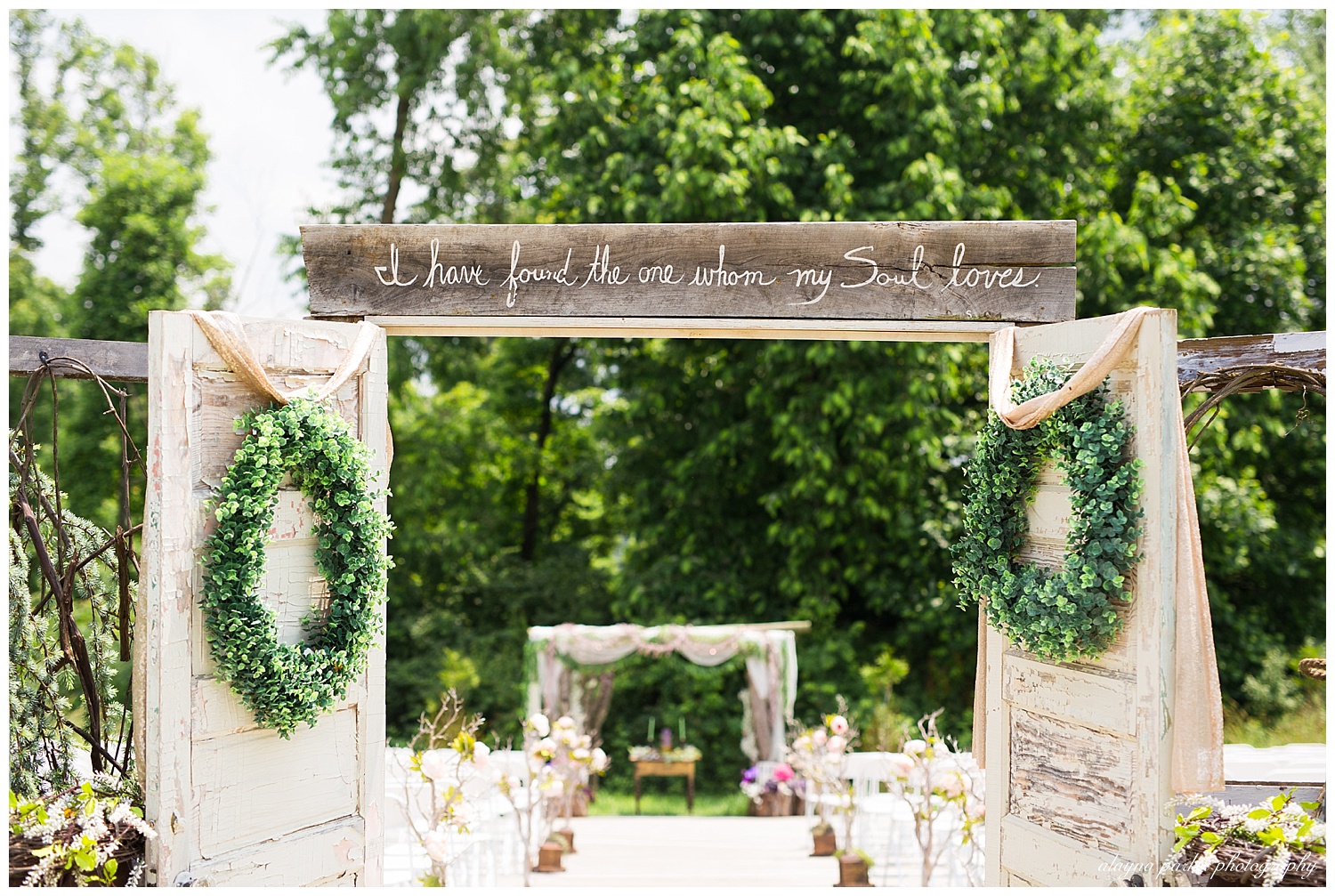 doors to ceremony with scripture quoted on wooden sign