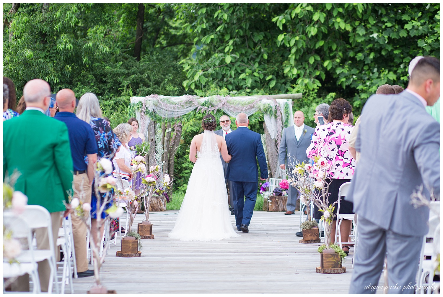 father and bride walking down the aisle outside at the barn on enchanted acres