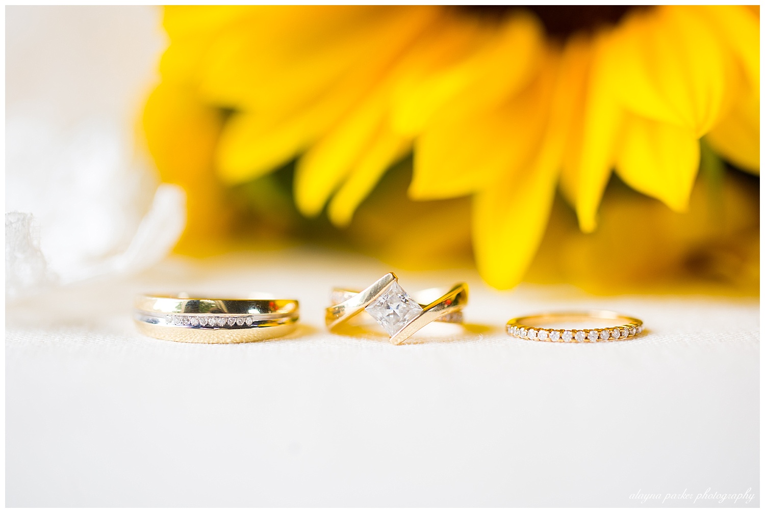 gold wedding rings with sunflower in background