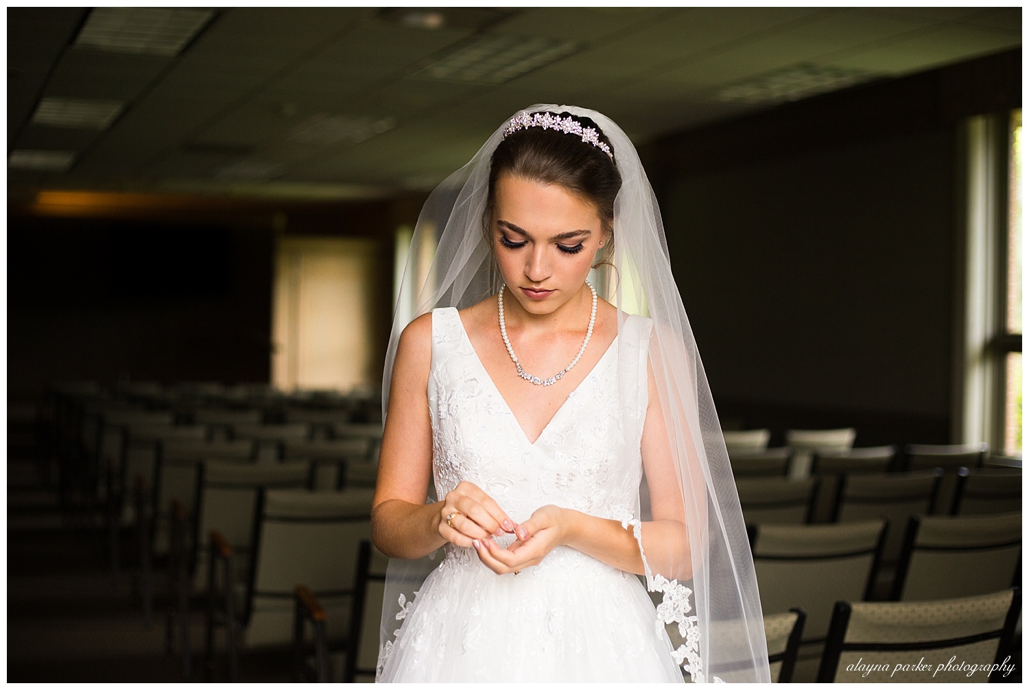bride getting ready to put earrings in