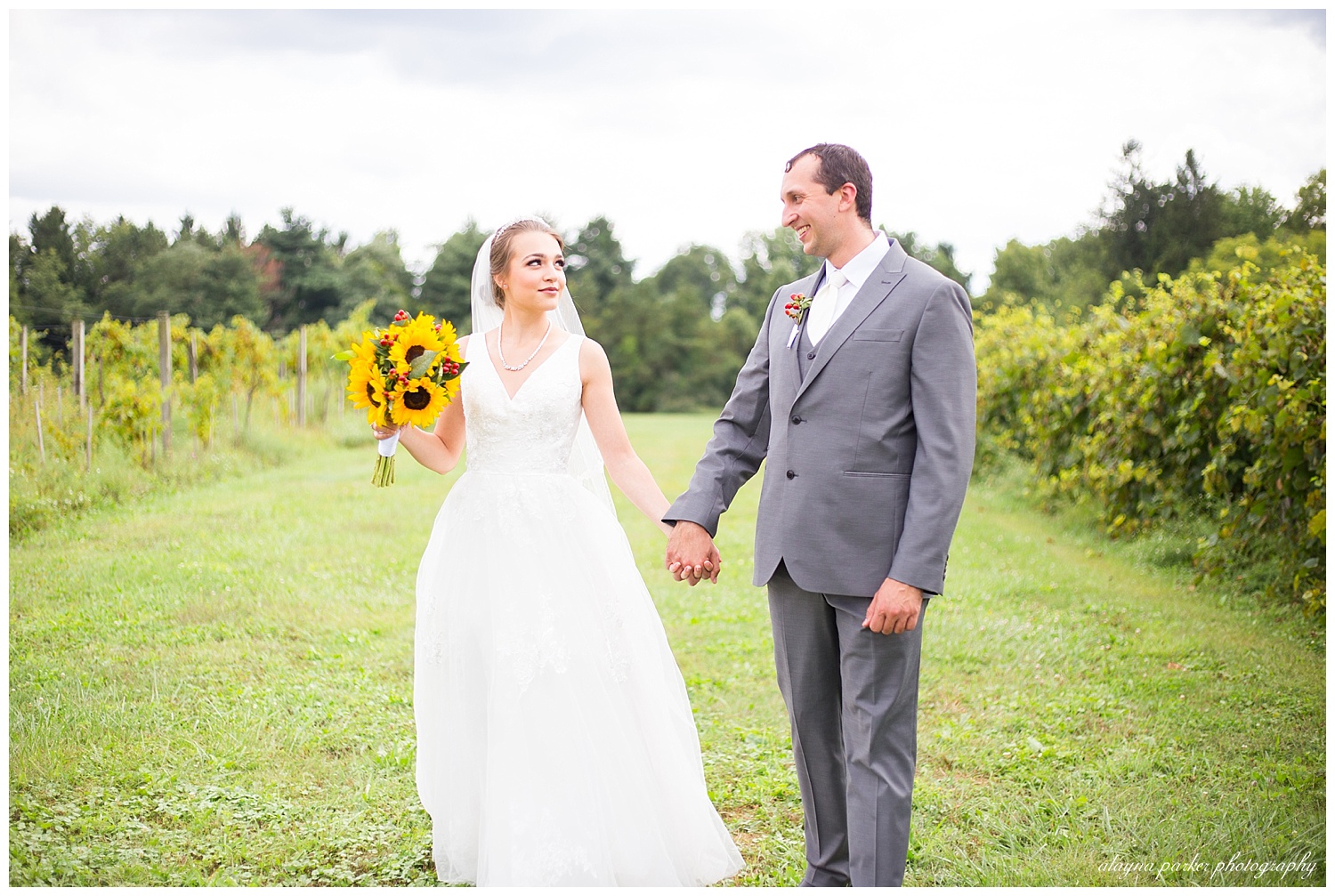 bride and groom looking at each other while walking at sarah's vineyard