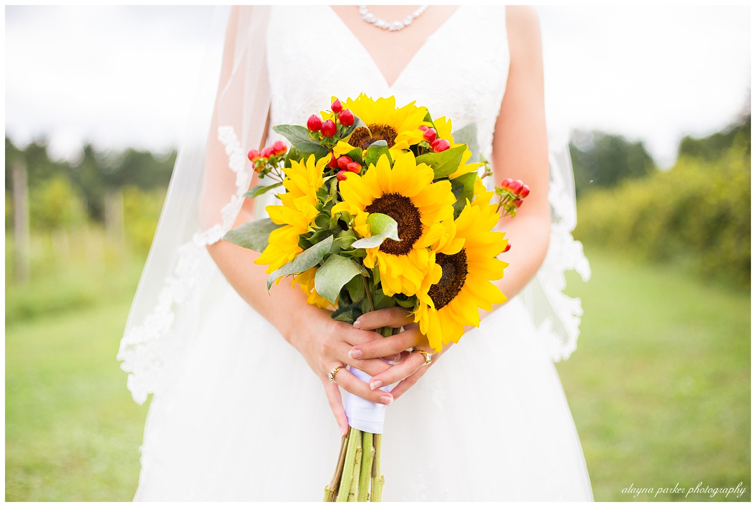 bride holding bouquet of sunflowers and red berries