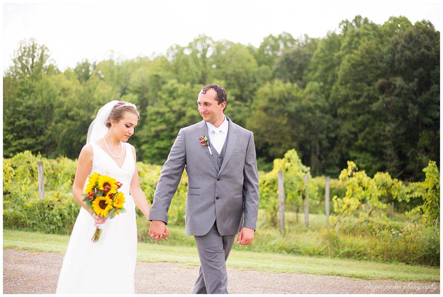 bride and groom holding hands while walking at sarah's vineyard