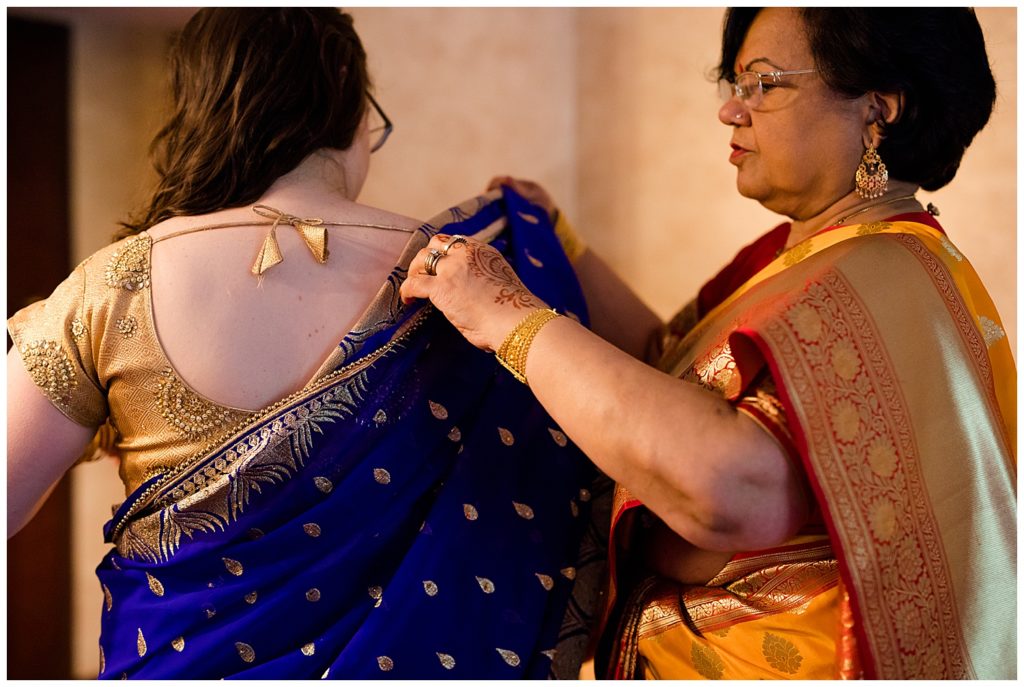woman getting dressed in saree