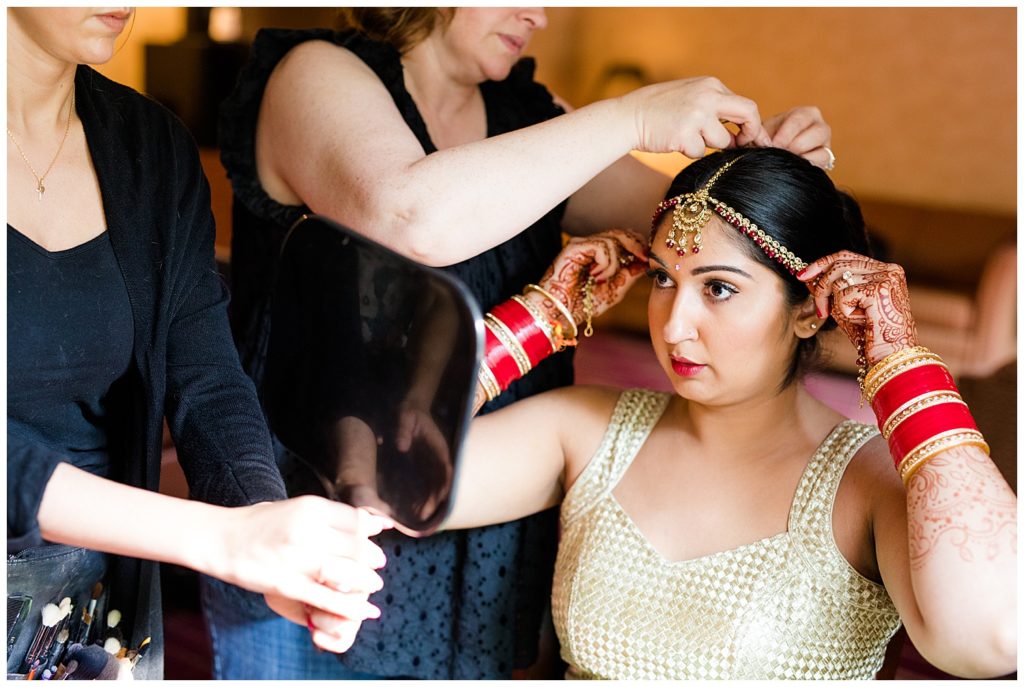 bride putting on indian headpiece