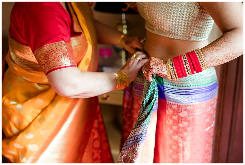 bride getting dressed in saree