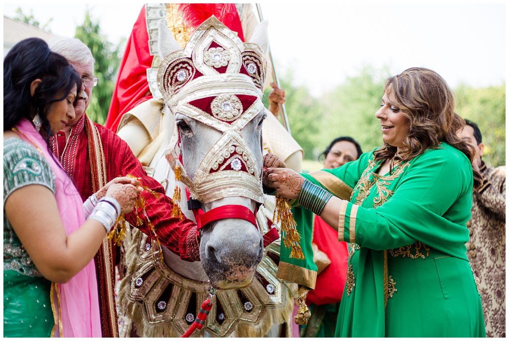 groom's sisters decorating horse for baraat