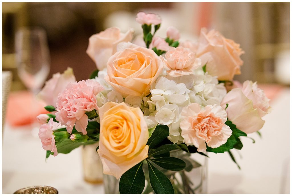 close up of centerpieces with white, pink, and peach flowers