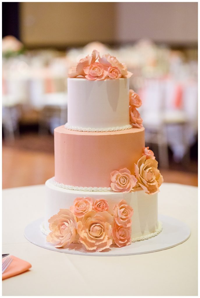 pink and white wedding cake with pink icing flowers
