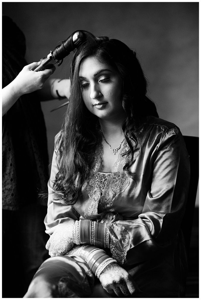 black and white image of bride getting hair curled