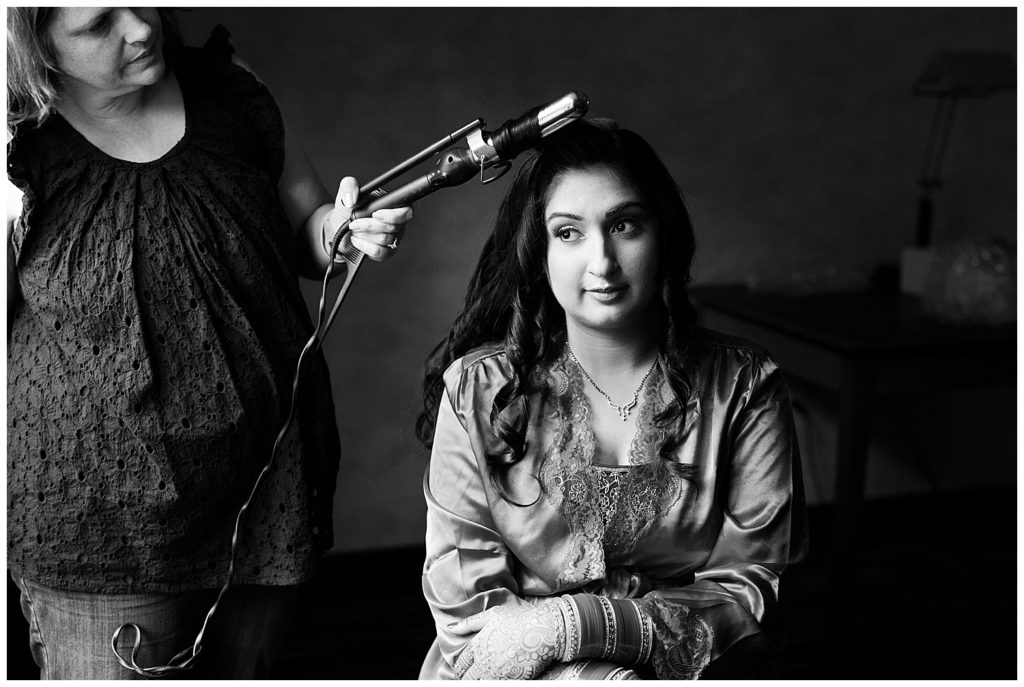 black and white image of bride getting hair done