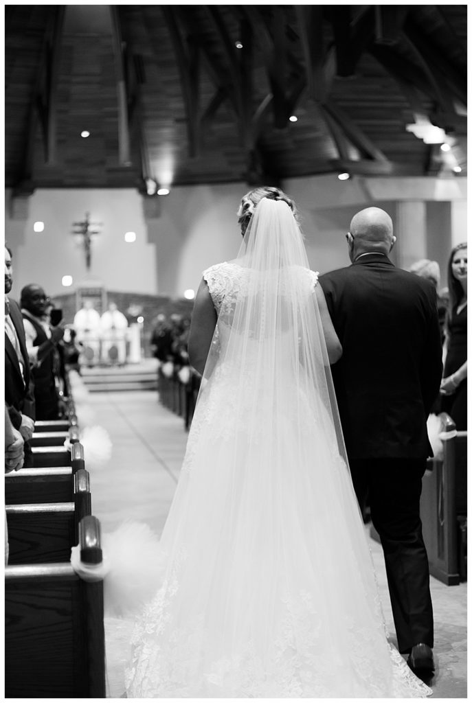 black and white image of father walking bride down the aisle