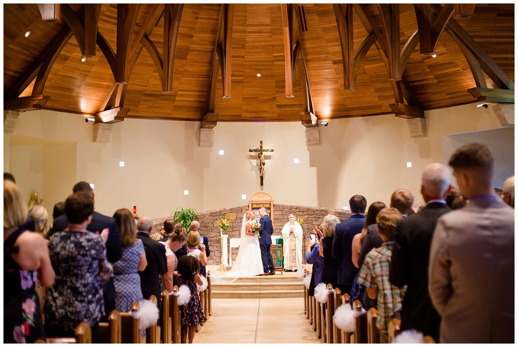 bride and groom smiling after first kiss
