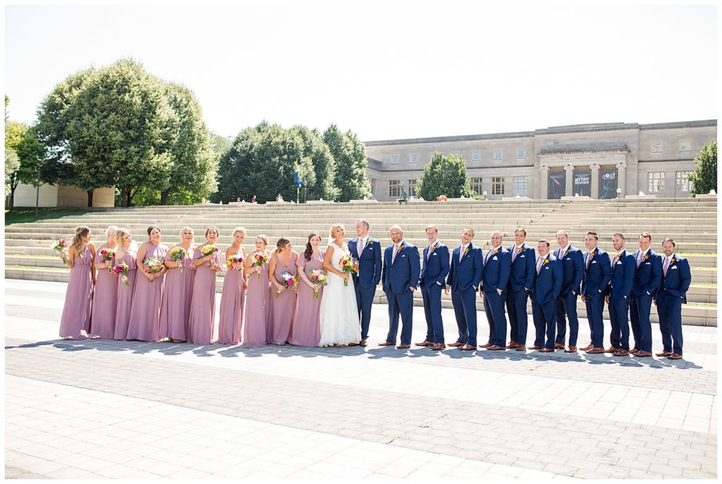 large bridal party in front of steps at cosi