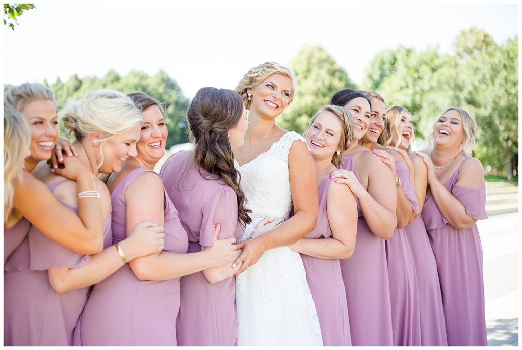bride and bridesmaids laughing in front of steps at cosi