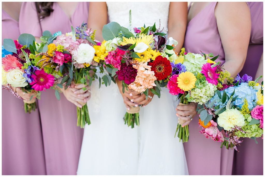 bride and bridesmaids holding colorful bouquets